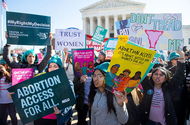 Abortion rally. A group of young women holding signs for increased abortion access outside the Supreme Court.