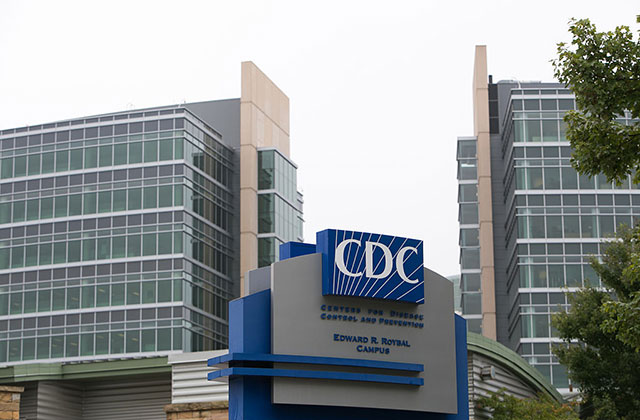Center for Disease Control. Building exterior showing  CDC logo on blue background surrounded by high-rise buildings.