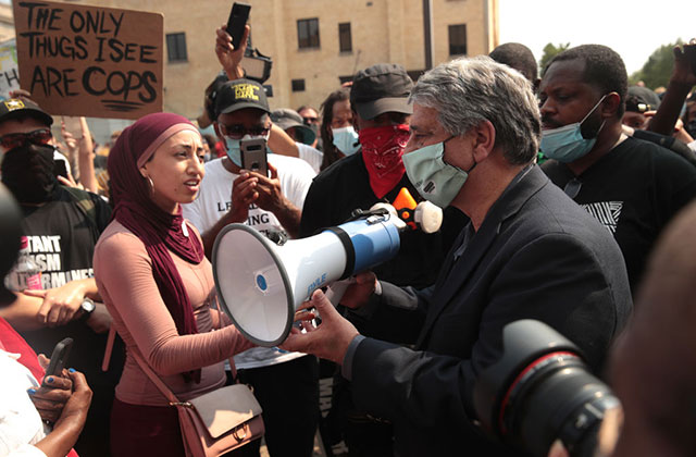 Jacob Blake protest. Crowd stands around a white man with gray hair holding a bullhorn.