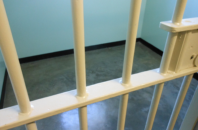 Yellow-painted prison bars, blue walls, gray floors.