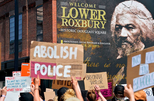 Abolish- police.Douglass. Photo of Federick Douglass behind a protest sign reading Abolish Police. 