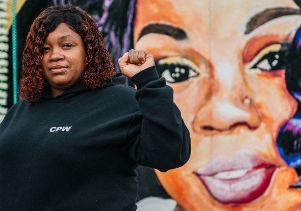 Breonna Taylor's mother, Tamika Palmer, raises her fist in salute, in front of her daughter's mural.