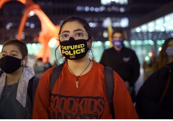 Image of woman wearing "defund police" face mask