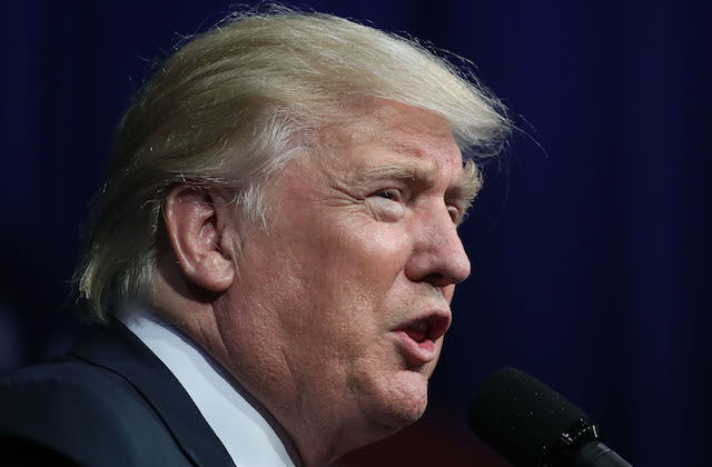White man in navy suit and white shirt against navy background