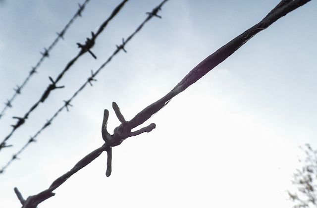 Black barbed wire with blue sky in background