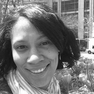 Angela Bronner Helm. Black woman smiles in the sunlight.