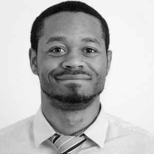 Joshua Addams in shirt and green tie smiling.