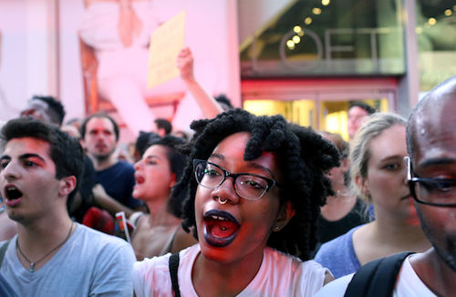 In New York City's Times Square a multiracial crowd protests against the fatal police shootings of Alton Sterling and Philando Castile.