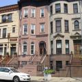 Bedford-Stuyvesant rowhomes in multiple colors with White car parked in front
