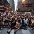 Hundreds of protestors sit in the street