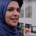 A young woman in a royal blue hijab smiles while being interviewed at the Women's March on Washington