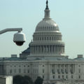 White surveillance camera in the foreground, U.S. Capitol in the background