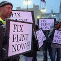 Black protestors holding signs to fix Flint 