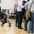 Baby in stroller waits as midterm election voters cast their ballots at Atlanta, Georgia's Grady High School polling station on November 6, 2018.