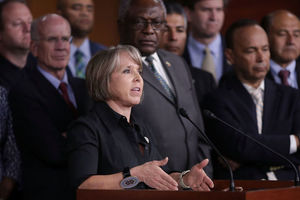 Latina woman with short hair speaks at a podium