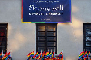Stonewall Inn with pride flags and plaque showing memorial.